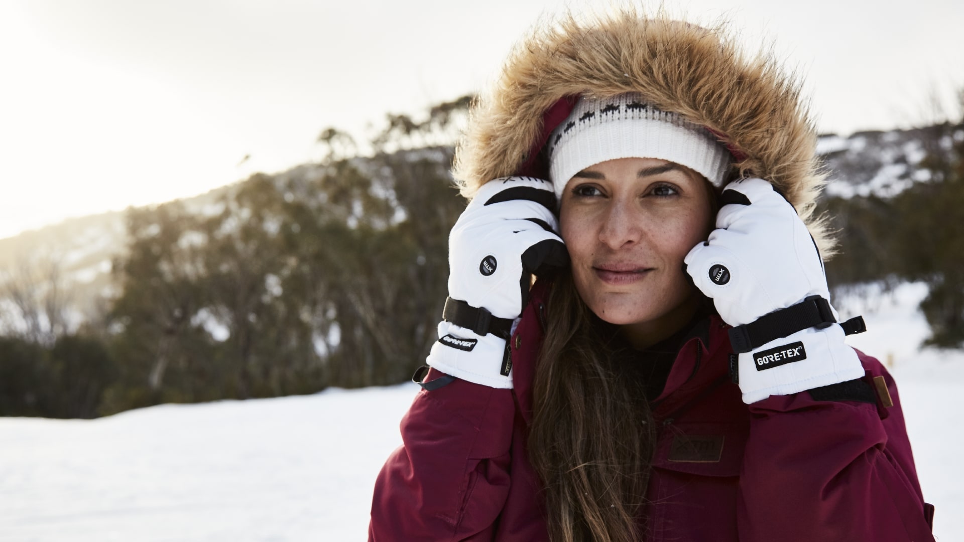 Woman wearing white beanie and XTM snow gloves