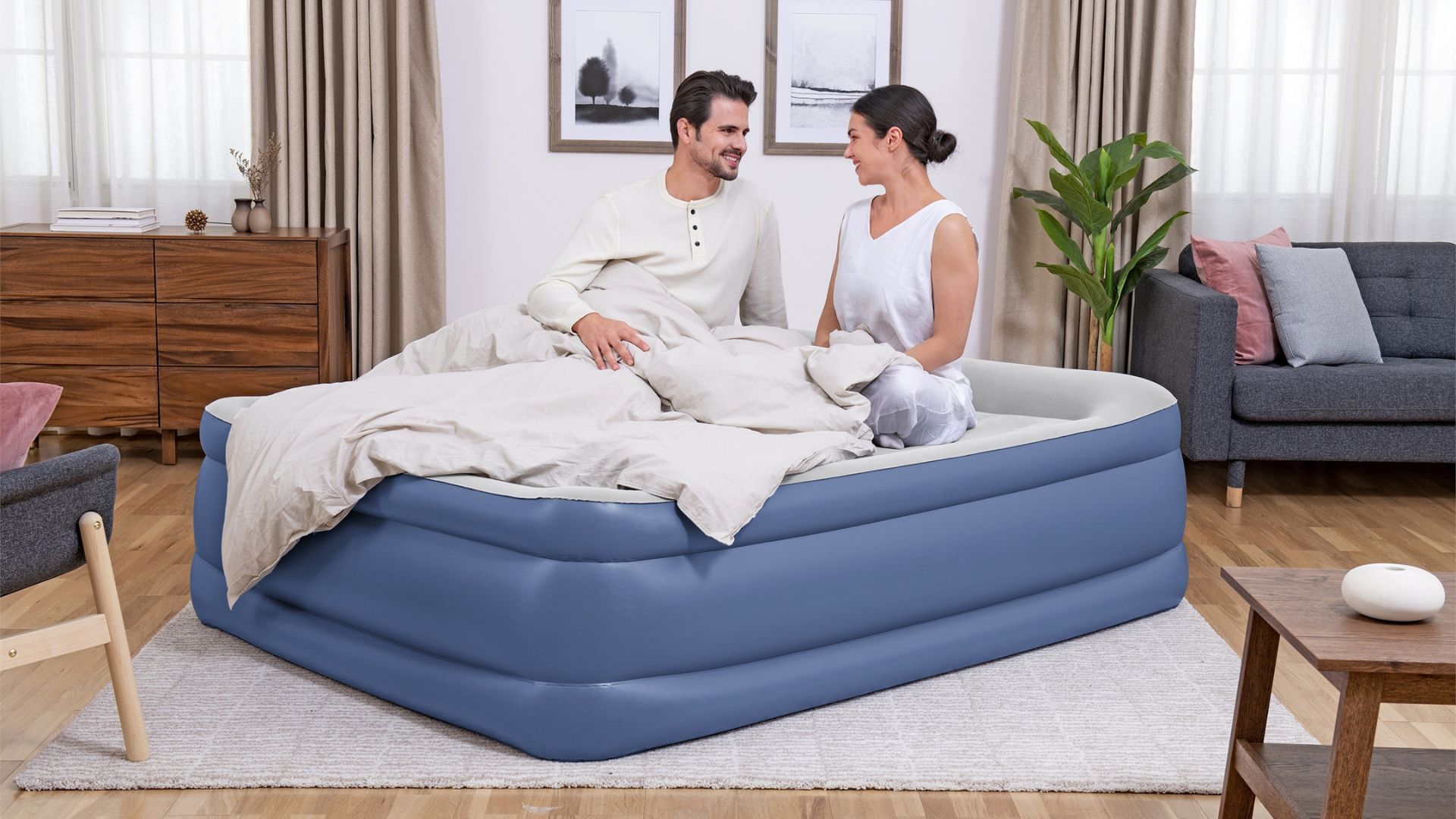 Couple sitting on an air mattress in the living room