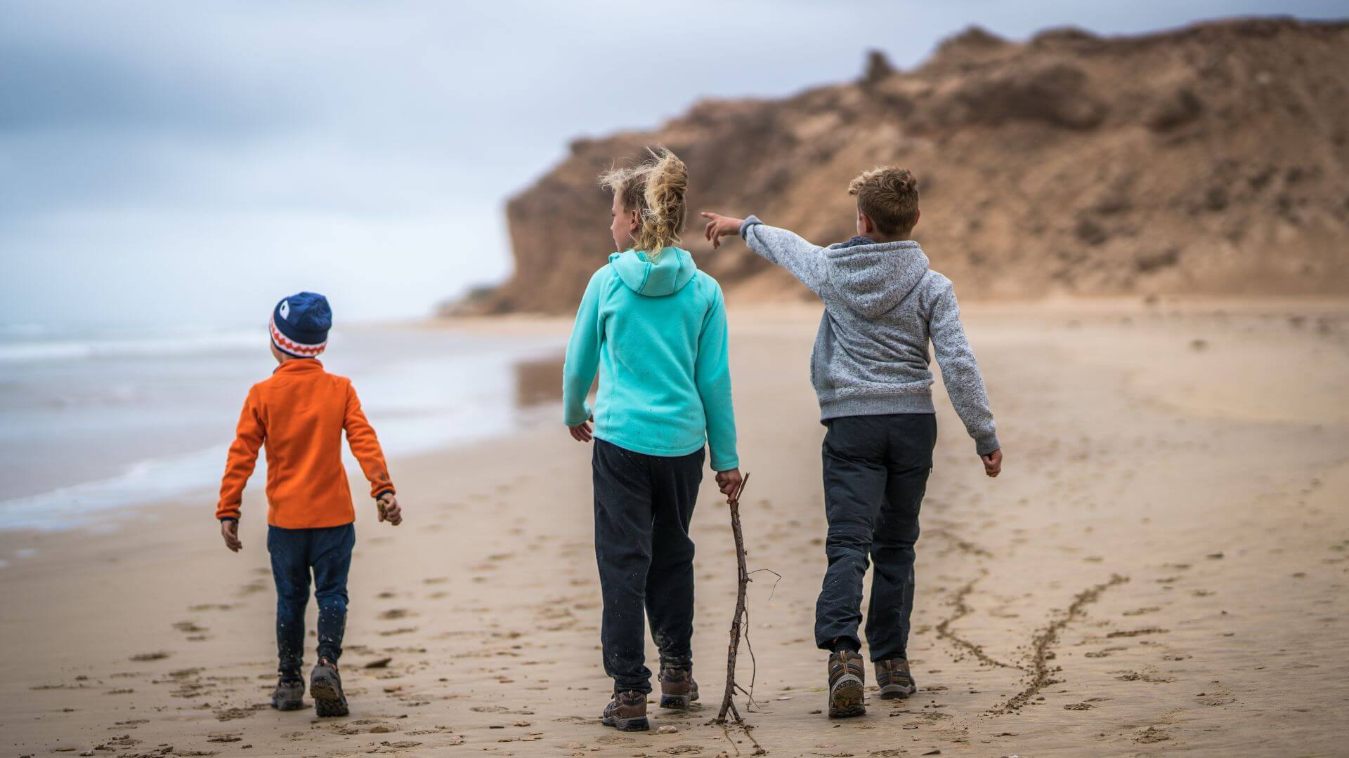 Kids Walking On Beach In Fleece Clothing