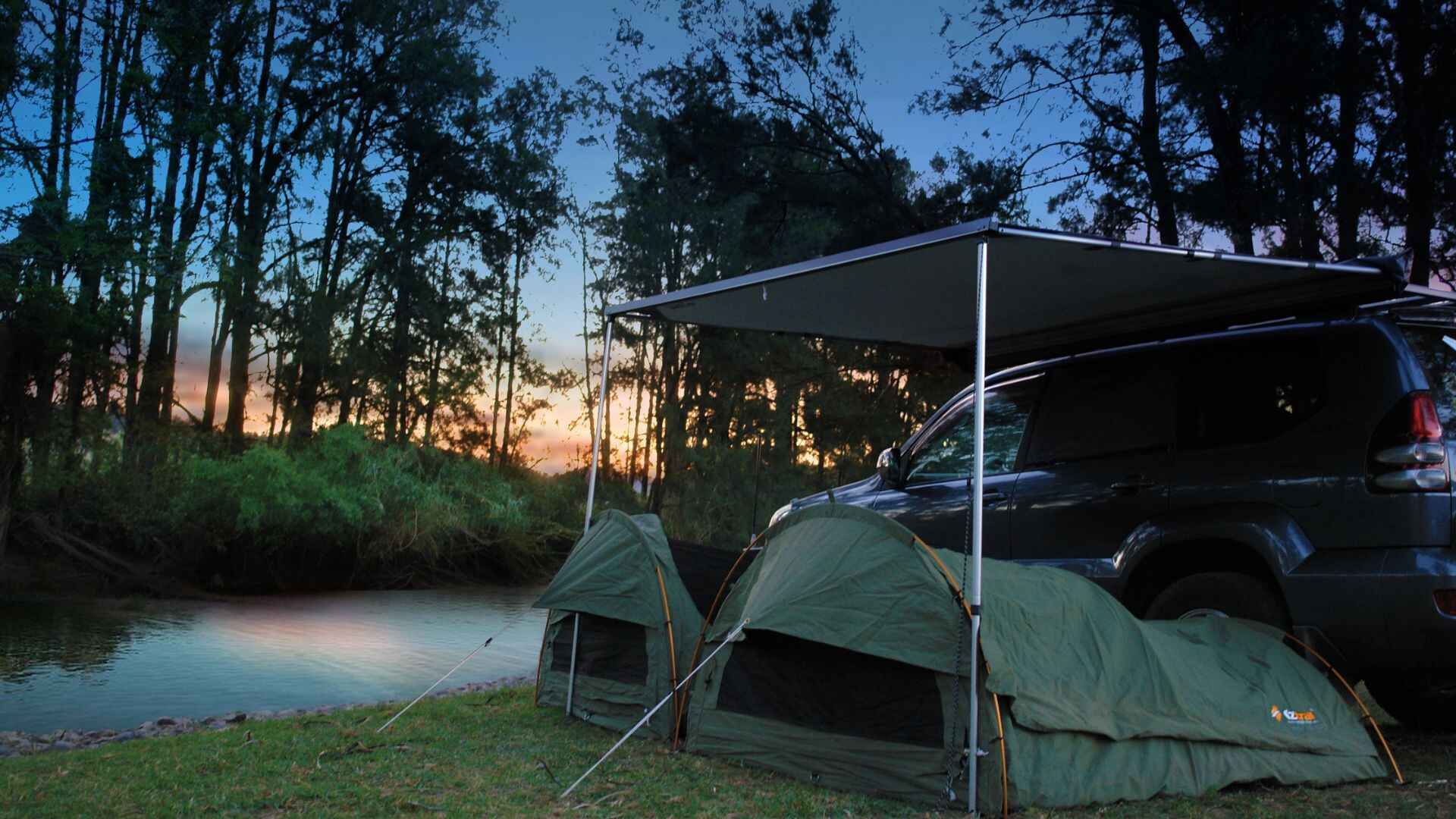 A Riverside Set Up Of Two OZtrail Single Swag Under Awning