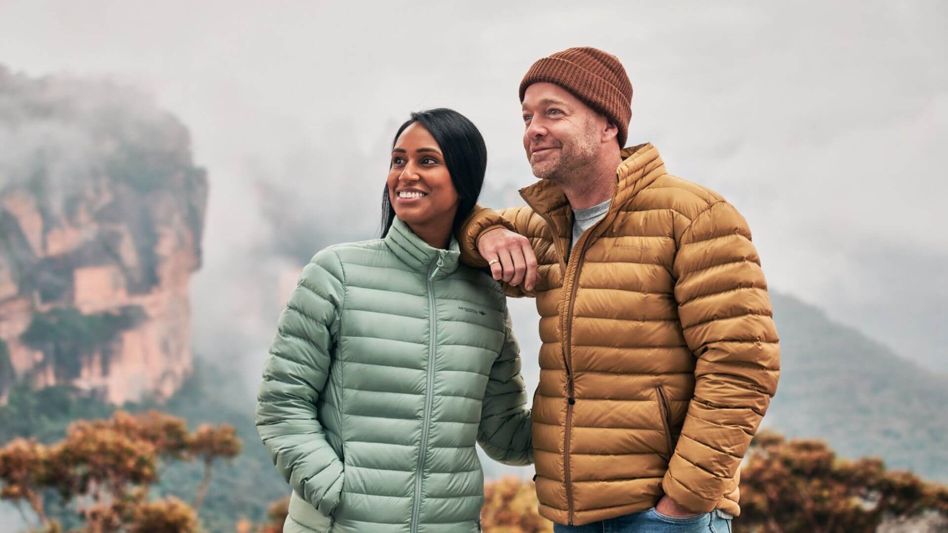 Man & Woman In Mountain Designs Puffer Jackets